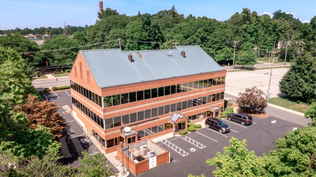 Aerial view of the office building at 178 Hartford Road in Manchester, Connecticut, showing the brick exterior, parking lot and landscaped property.