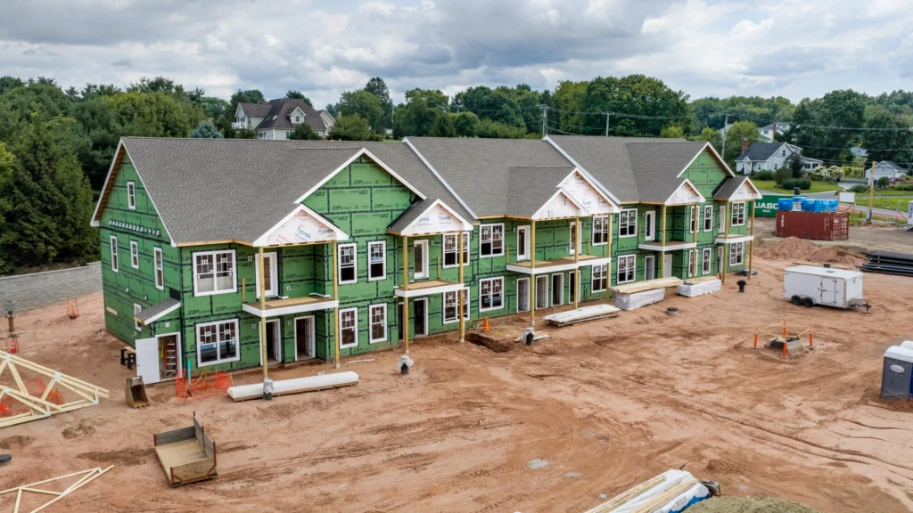 Aerial view of apartment buildings under construction at 241 Deming Street in South Windsor, Connecticut, showing exterior framing and active site work.