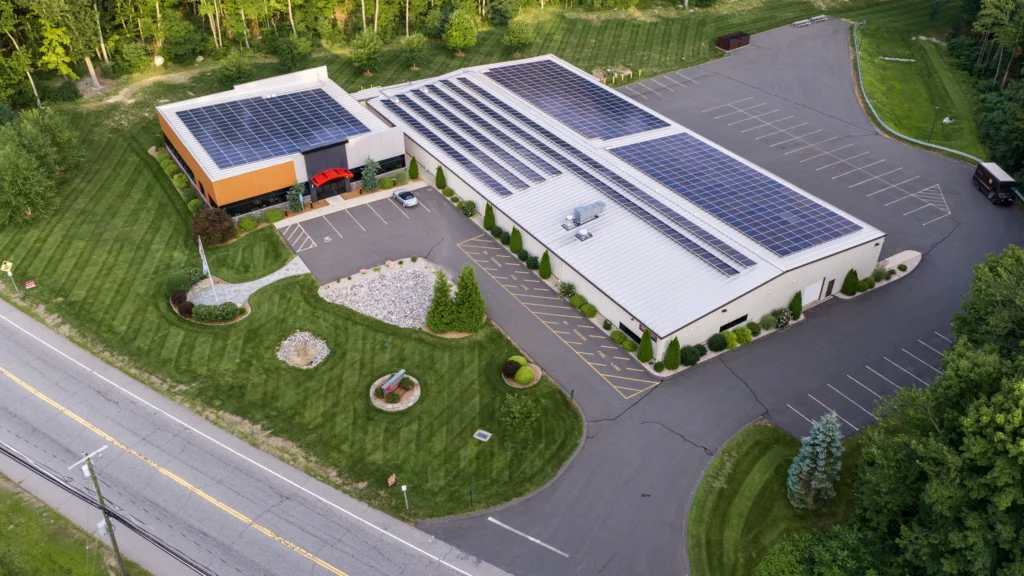 Aerial view of the Able Coil & Electronics facility in Bolton, Connecticut, showing the building, solar panels, parking areas and landscaped grounds.