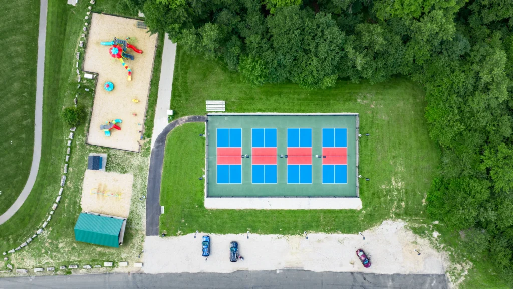 Top-down aerial view of a park in Andover, Connecticut, showing colorful pickleball courts, playground areas and surrounding green space.