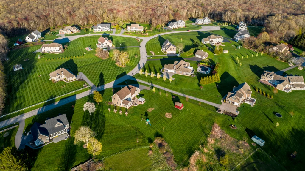 Aerial view of the High Ridge Farms subdivision in Bolton, Connecticut, showing homes, large lawns, winding roads and surrounding woodland.