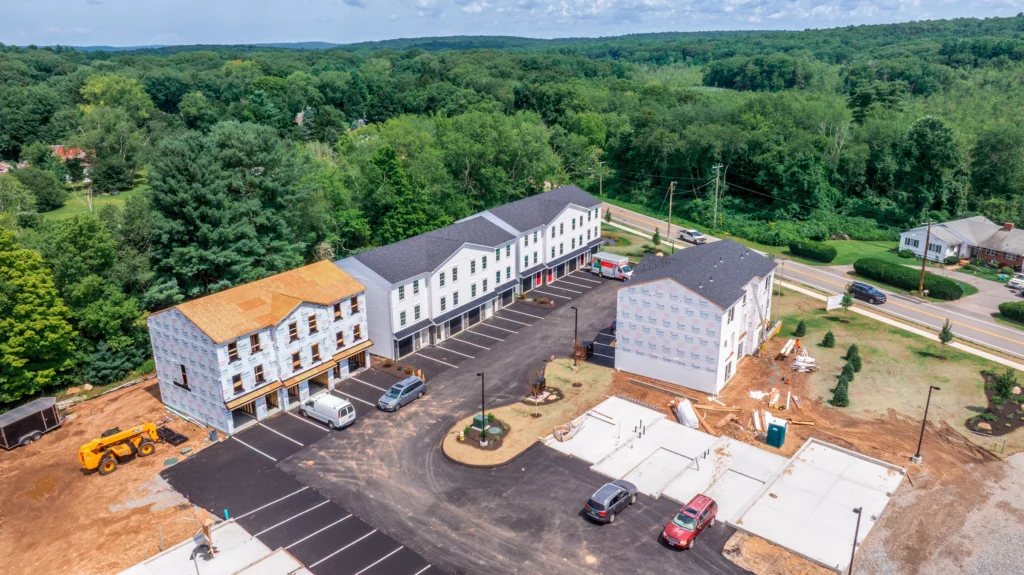 Aerial view of Meadow Brook Landing apartment buildings under construction in Colchester, Connecticut, showing multiple buildings and active site work.