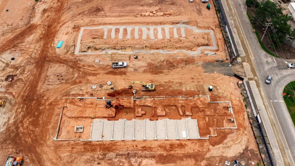 Top-down aerial view of the Silk City Commons construction site in Manchester, Connecticut, showing excavation, foundations and active site work.