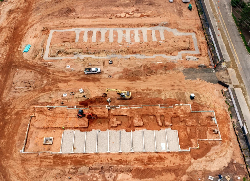 Top-down aerial view of the Silk City Commons construction site in Manchester, Connecticut, showing excavation, foundations and active site work.